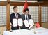 覚書に署名した早川市長とナム委員長