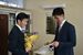 板倉教諭（右）から花束と色紙を受け取る小室さん