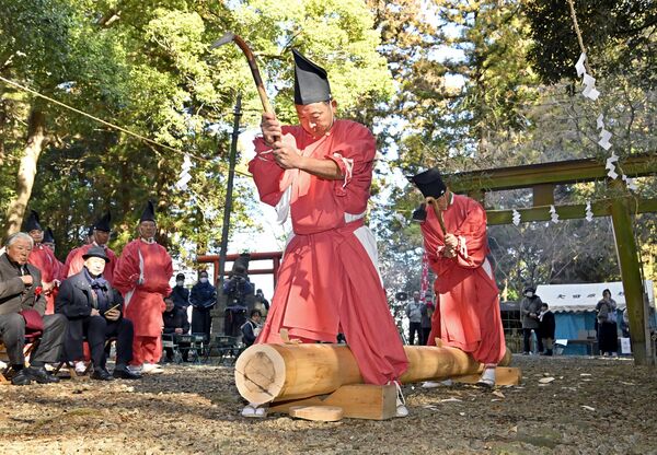 ちょうなで丸太を削る狩衣姿の大工たち＝11日午前11時35分、大田原市山の手２丁目
