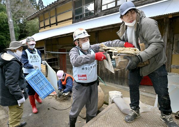 多くのボランティアと力を合わせ、災害廃棄物の撤去作業に汗した矢板市の介護福祉士木川佳明さん（右から２人目）＝２月28日午後２時30分、石川県穴水町