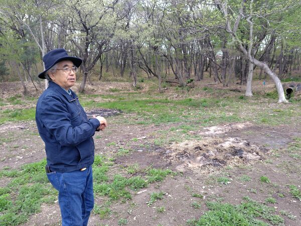 山菜などが芽吹いている春の里山の自然林を案内する室井社長＝４月、那須町