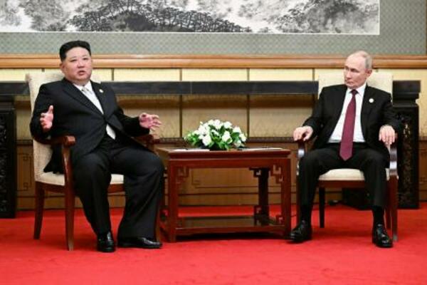 するロシアのプーチン大統領（右）と北朝鮮の金正恩朝鮮労働党総書記＝３日、北京（タス＝共同）