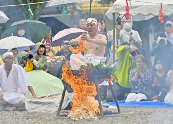 参拝者が見守る中、釜の湯に入り経を唱える長浜住職＝28日午前11時35分、那須塩原市沼野田和
