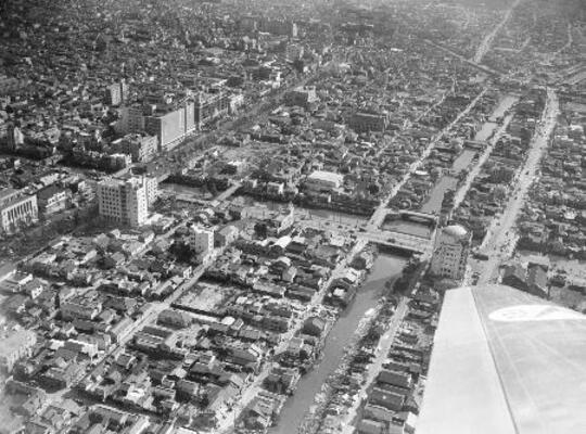 　大阪中心部の空撮、市北西部から難波方面を撮影。西横堀川（下から右上へ）と交差する長堀川（交差点の橋は四つ橋）＝１９５３年