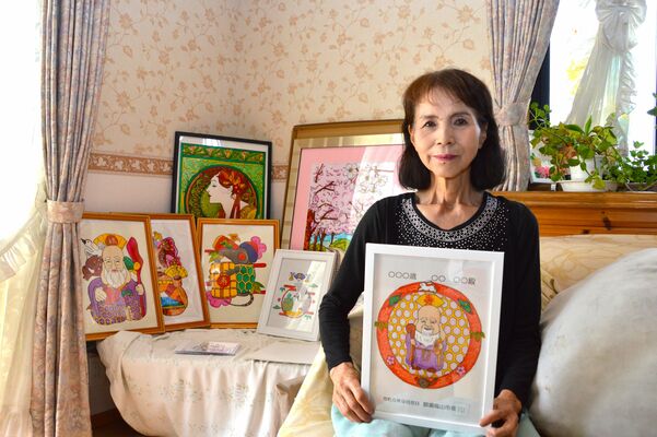 今年の記念品を掲げる荒井さん