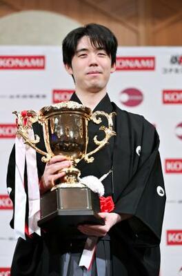 将棋の棋王就位式でトロフィーを手にする藤井聡太棋王=16日午後、東京都内のホテル