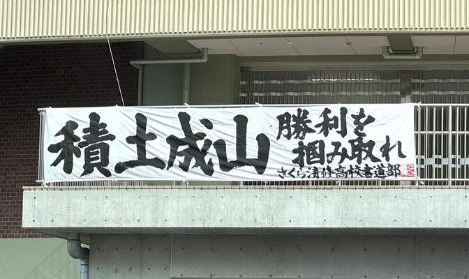 球場入り口に掲げられたさくら清修高書道部による横断幕＝エイジェックスタジアム