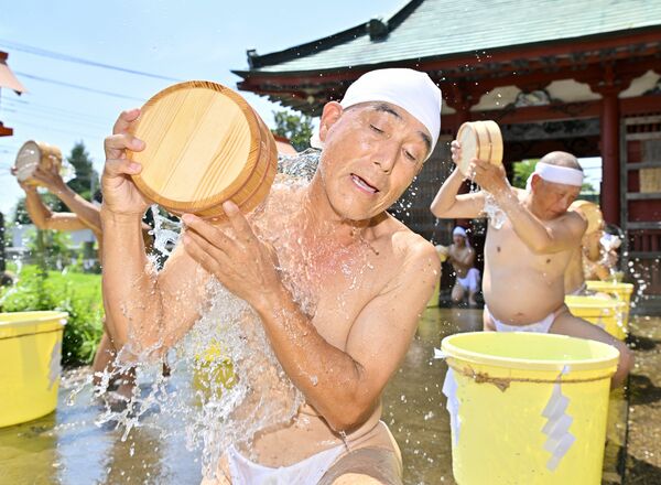 勢いよく水をかぶり身を清める参加者=22日午前10時20分、真岡市長沼