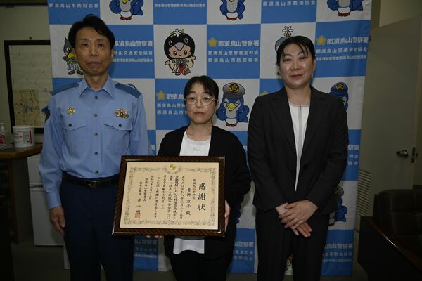 井上署長（左）から感謝状を受け取った青柳さん（中央）