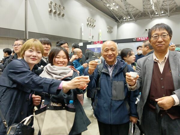 「にいがた酒の陣」で日本酒を味わう筆者（右から２人目）らグループ＝３月８日、新潟市