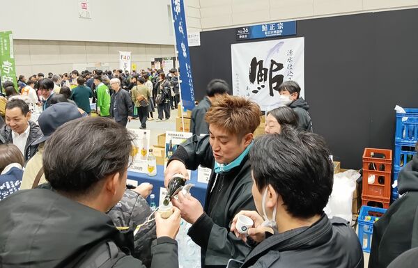 次々に酒を注いでくれる「２０２６にいがた酒の陣」各蔵ブース＝３月８日、新潟市