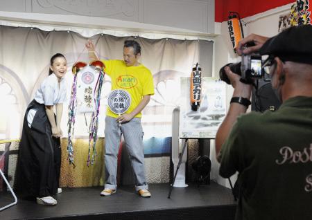男性ファンが持参したくす玉を割る山西アカリさん(左)=東京都台東区