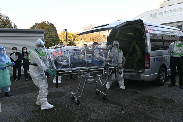 エボラ出血熱を想定した患者の移送訓練を行う参加者＝10日午後、下野市薬師寺