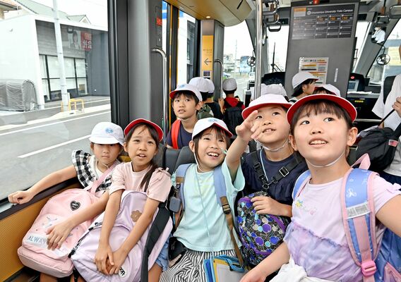 社会科見学のため集団乗車し、興味津々の様子の児童たち＝14日午前８時55分、宇都宮市陽東４丁目