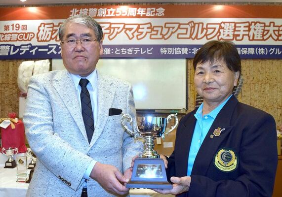 須藤大会会長から優勝カップを受け取る秋山（右）