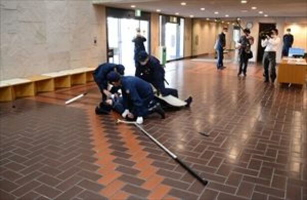 取り押さえられる不審者役の警察官＝29日午前、宇都宮市本町
