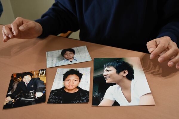 写真を前に勇輔さんへの思いを語る母。撮影を恥ずかしがり、中学・高校時代の写真は少ないという＝11日午前、宇都宮市内
