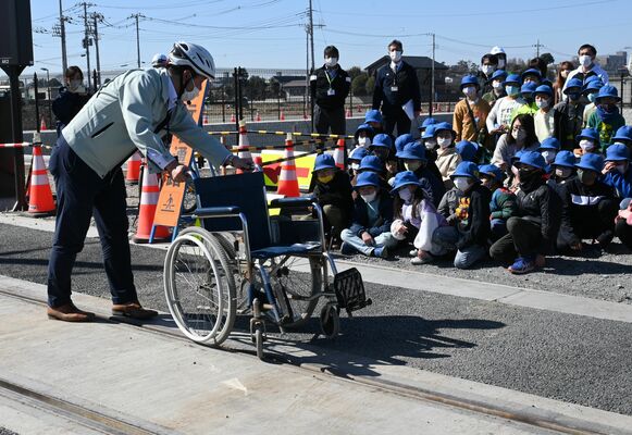 軌道敷を車いすで渡る際の注意点を学ぶ児童ら