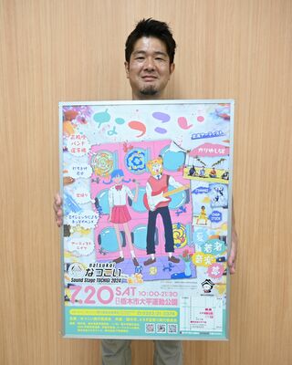 なつこいのポスターを持つ川田実行委員長