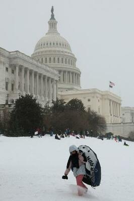 25日、ワシントンの米議会議事堂近くを歩く人(ロイター=共同)