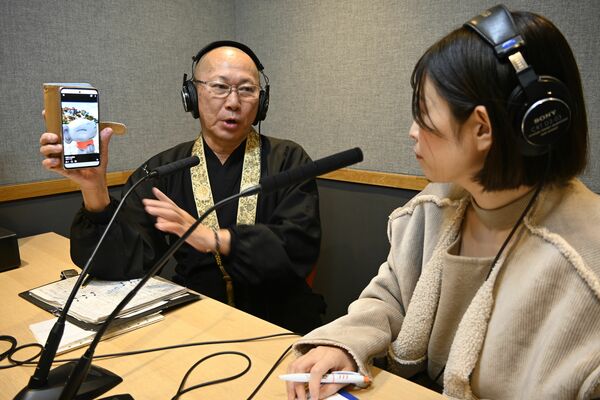 収録の打ち合わせで和顔地蔵について説明する高岡住職（左）＝３日午後、宇都宮市昭和２丁目