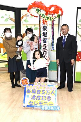 ５万人目の来場者となった杉野志歩ちゃん（手前中央）と家族