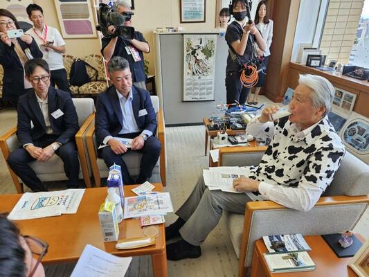和泉委員長（前列中央）から贈られた牛乳を試飲する福田知事（右）＝５日午前、県庁