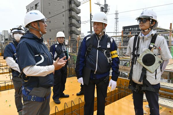 工事現場で安全対策の説明を受ける中野局長(中央)=1日午後、宇都宮市元今泉1丁目