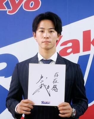 　契約更改交渉を終え、来季の抱負を記した色紙を手にするヤクルト・内山＝１１日、東京都内の球団事務所
