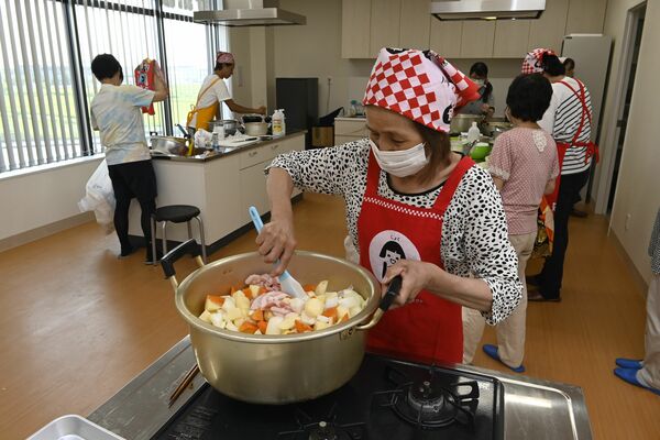 ＪＡ宇都宮南部支所で開催された子ども食堂の出張企画で、食事を準備するスタッフ＝６月30日午後、宇都宮市砂田町