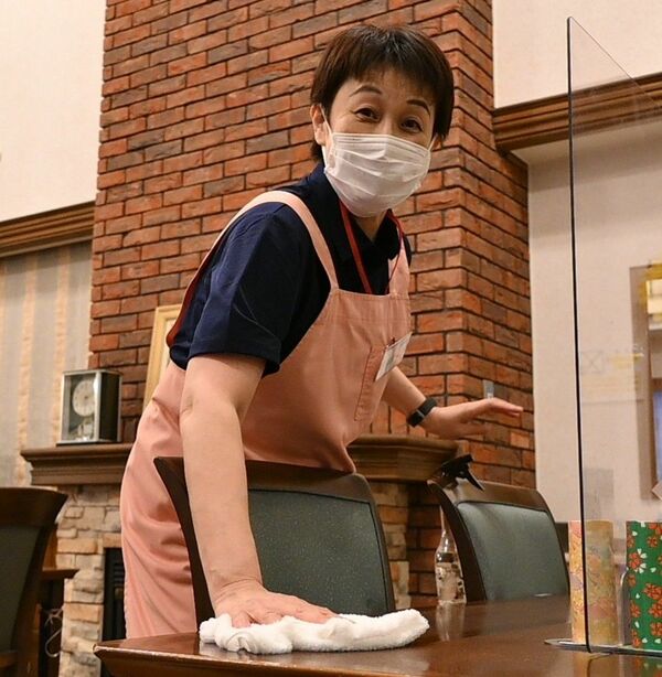 施設の食堂のテーブルを拭き上げる石川さん＝４月下旬、宇都宮市中岡本町