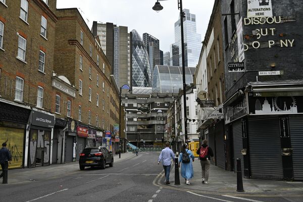 週末には買い物客でにぎわう通りからは、隣接する金融街シティー・オブ・ロンドンの高層ビル（奥）が見える＝５月24日午後