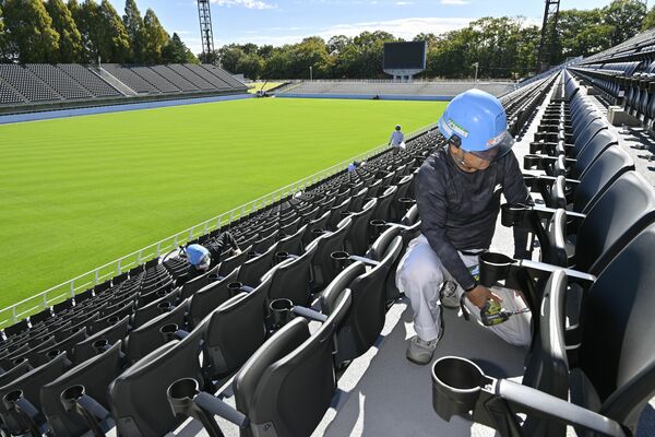 黒一色に様変わりしたメインスタンドの座席取り付け作業=28日午前10時20分、宇都宮市清原工業団地