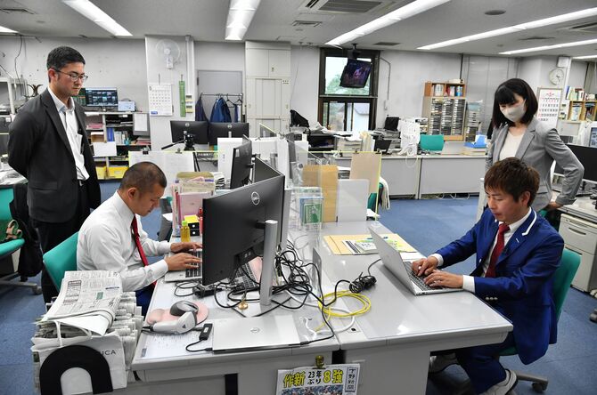 社長インタビューの記事を執筆する益子さん(手前左)と福田さん(同右)=5月22日午後3時24分=下野新聞本社