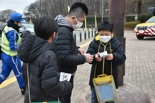 那須高原ＳＡの来場者たちに牛乳レシピを配布する児童たち（右、左）