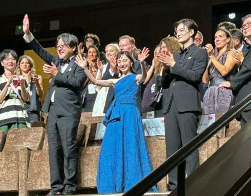 　ベネチア国際映画祭での「果てしなきスカーレット」の公式上映後、観客からの拍手に応える（前列左から）細田守監督、芦田愛菜さん、岡田将生さん＝２０２５年９月、イタリア・ベネチア（共同）