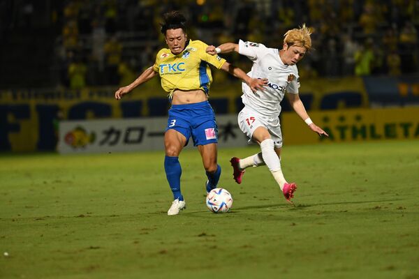 前半23分、栃木ＳＣの黒崎が激しく競り合う＝県グリーンスタジアム