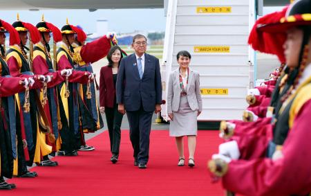 　韓国・釜山の金海国際空港に到着し、出迎えを受ける石破首相。右は妻の佳子さん＝９月３０日（共同）