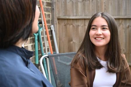 　選挙権年齢の引き下げについて母親と話すキミコ・フラナガンさん（右）＝８月、ロンドン（共同）