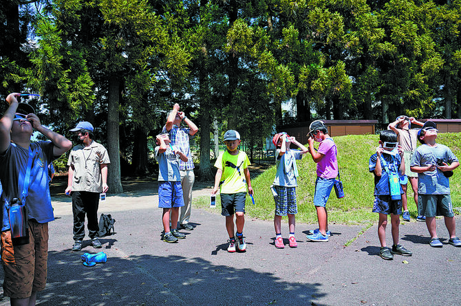 昨年の夏休み科学教室。遮光眼鏡を使って太陽を観察（提供写真）