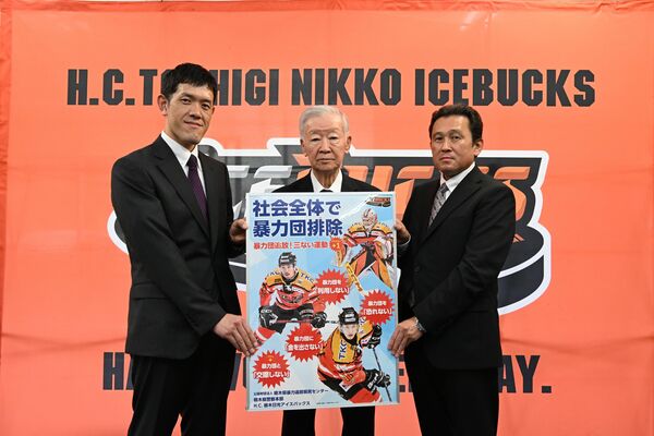 ポスターを披露するセルジオ越後さん（中央）ら＝12日午前、日光市松原町