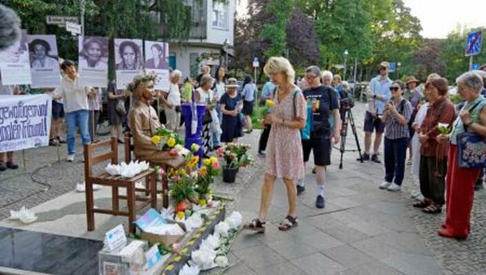 　１４日、ベルリン市ミッテ区の公有地にある少女像に献花する集会参加者（共同）