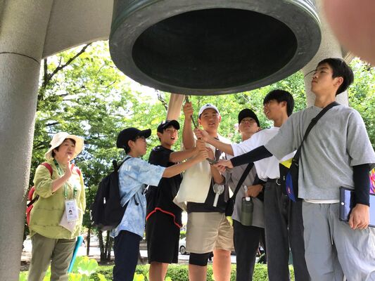 平和記念公園内の平和の鐘を鳴らす生徒たち
