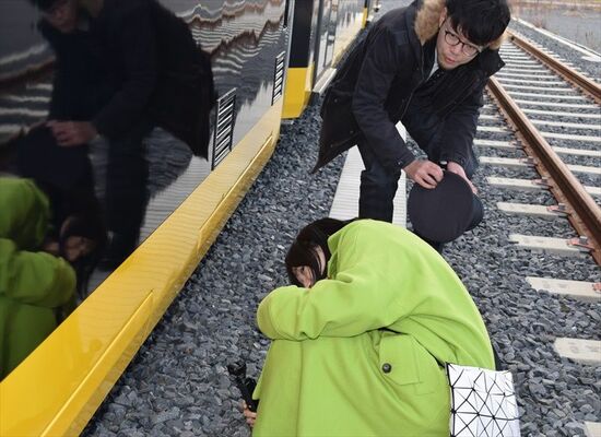 ＬＲＴの車両下をのぞき込む鈴川さん（手前）