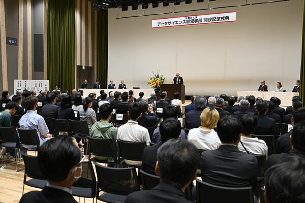データサイエンス経営学部の開設記念式典に出席する関係者＝25日午後、宇都宮市