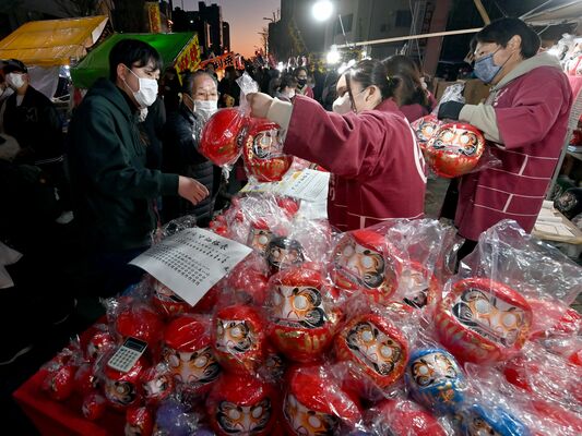 だるまなど縁起物を買い求める人たち＝11日午後５時10分、宇都宮市大通り５丁目（超広角レンズ使用）