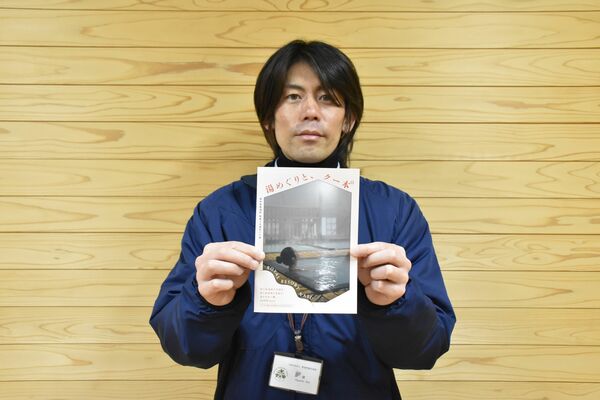 冊子を持つ林さん