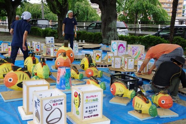宇都宮空襲の犠牲者を追悼する灯籠を準備するピースうつのみやの会員ら=2018年、宇都宮市千波町(ピースうつのみや提供)