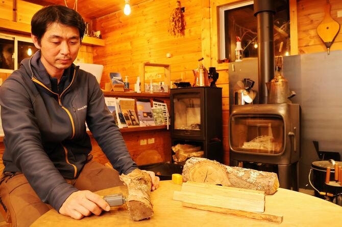 ナラのまきに含まれる水分の割合を調べる斎藤さん。乾燥不足は臭いの原因になる＝昨年12月18日、長野市