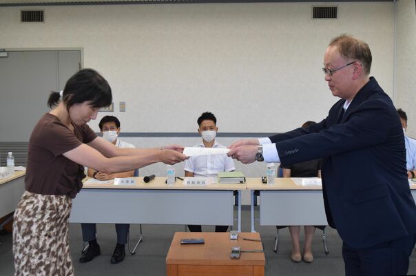 本県の最低賃金改定に関する答申書を栃木労働局の奥村英輝局長（右）に手渡す栃木地方最低賃金審議会の杉田明子会長＝７日午後、宇都宮市内